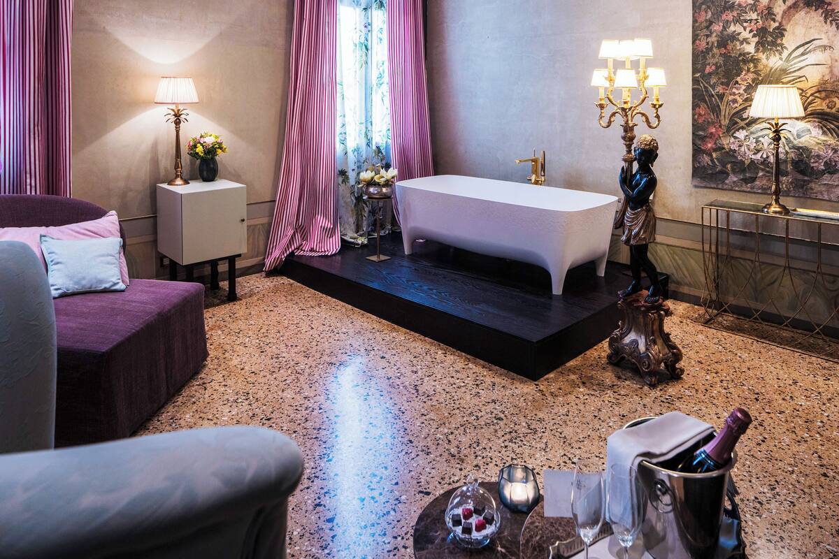 A modern bathroom with a bathtub, a vanity, and a large mirror.