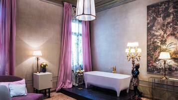 A modern bathroom with a bathtub, a vanity, and a large mirror.