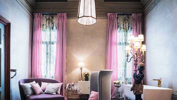 A room with a sofa, armchair, and a statue.
