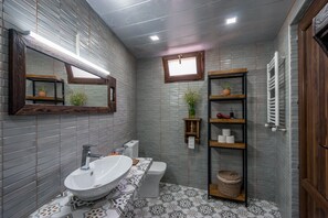Ein Badezimmer mit einem großen Waschbecken, Toilette und Regalen mit Pflegeprodukten.