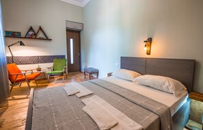 Ein Schlafzimmer mit Bett, Stuhl, Schreibtisch und Lampe.