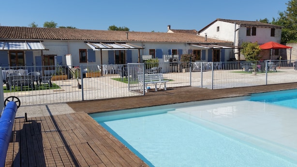 Una piscina con muelle de madera y patio amurallado.