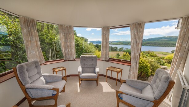 A room with four chairs and a table, large windows with curtains, and a view of a lake and hills. - Peaceful Farm Cottage in the 'Heart of Argyll' over-looking Loch Awe (Dalmally)