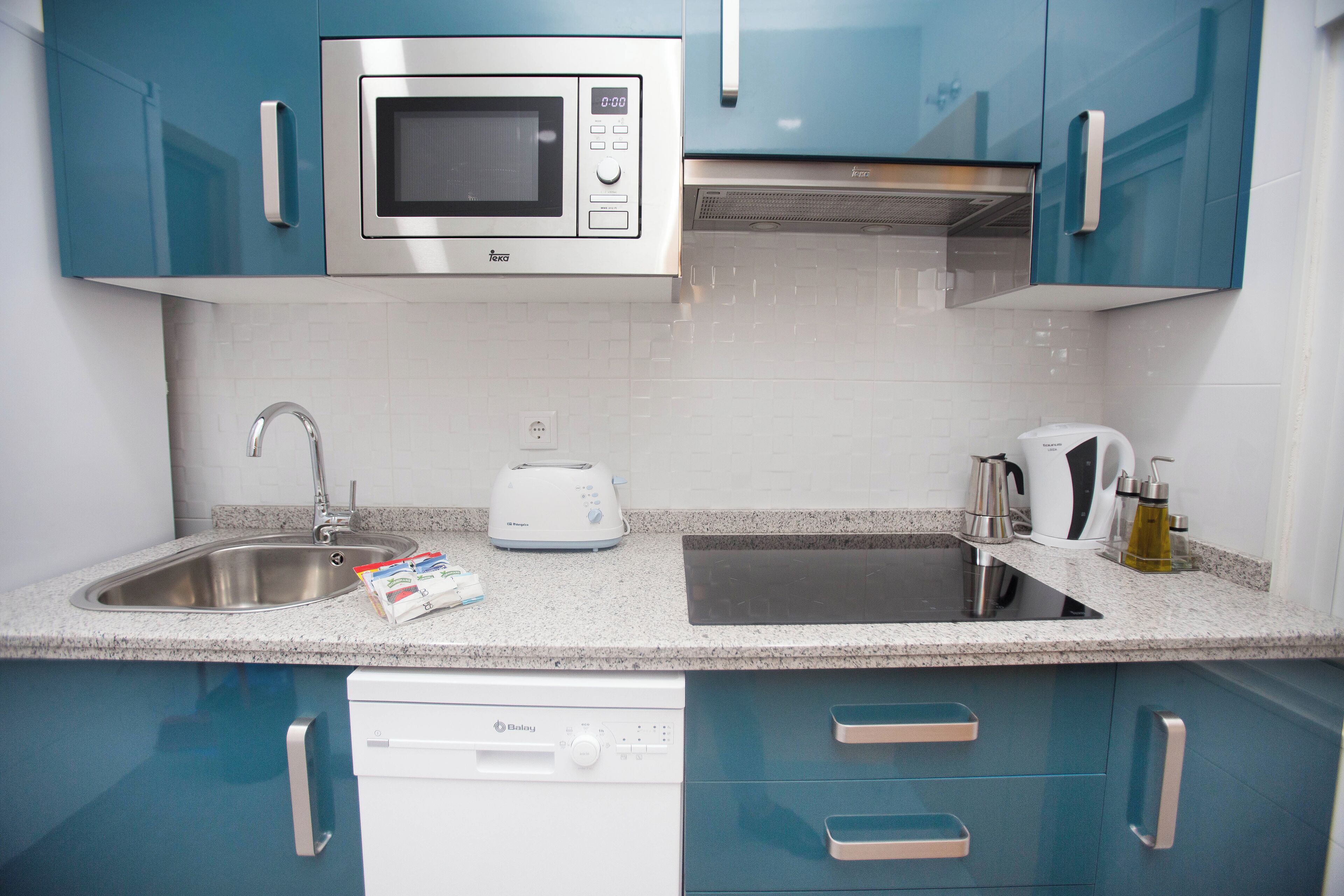 Una cocina moderna equipada con microondas, tostadora y lavavajillas integrados.