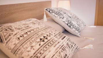 Una cama con almohadas estampadas y un cabecero de madera.