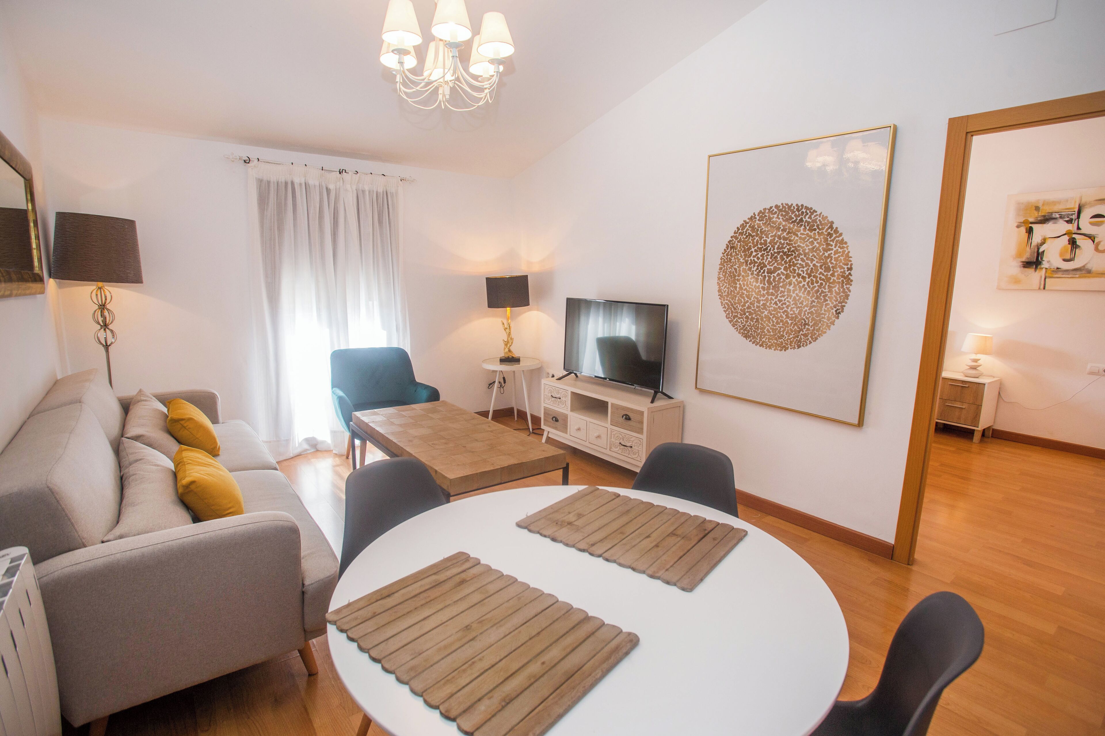 Una sala de estar moderna con sofá, televisor y comedor.