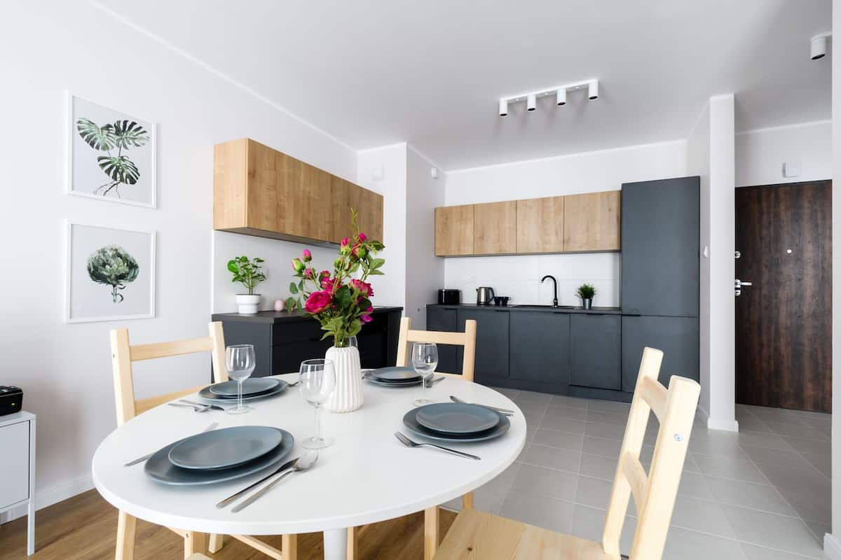 A modern kitchen with dark cabinets, a white countertop, and a built-in oven.