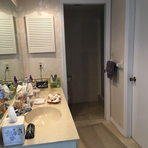 A bathroom with a large sink, a mirror, and a towel rack.