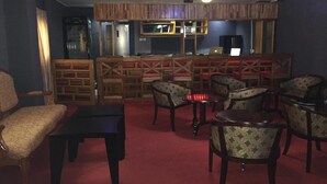 Un espace bar avec des meubles en bois et une moquette rouge.