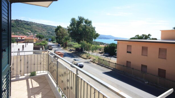 Ein Balkon mit Blick auf eine Straße, ein Gebäude und ein weiter Wasserblick.