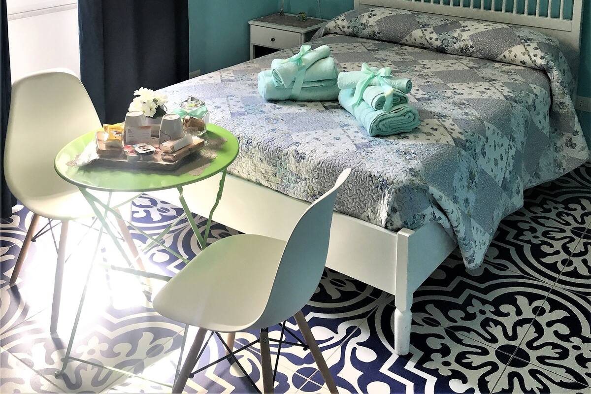 Une chambre à coucher avec un lit, une table de chevet, une chaise et une table.