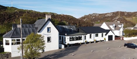 A white building with a sign reading "The Drumling Hotel".