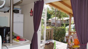 A kitchen with a microwave, coffee maker, and a basket of vegetables. - Camping Tikayan La Vallée du Paradis (Saint-Raphael)