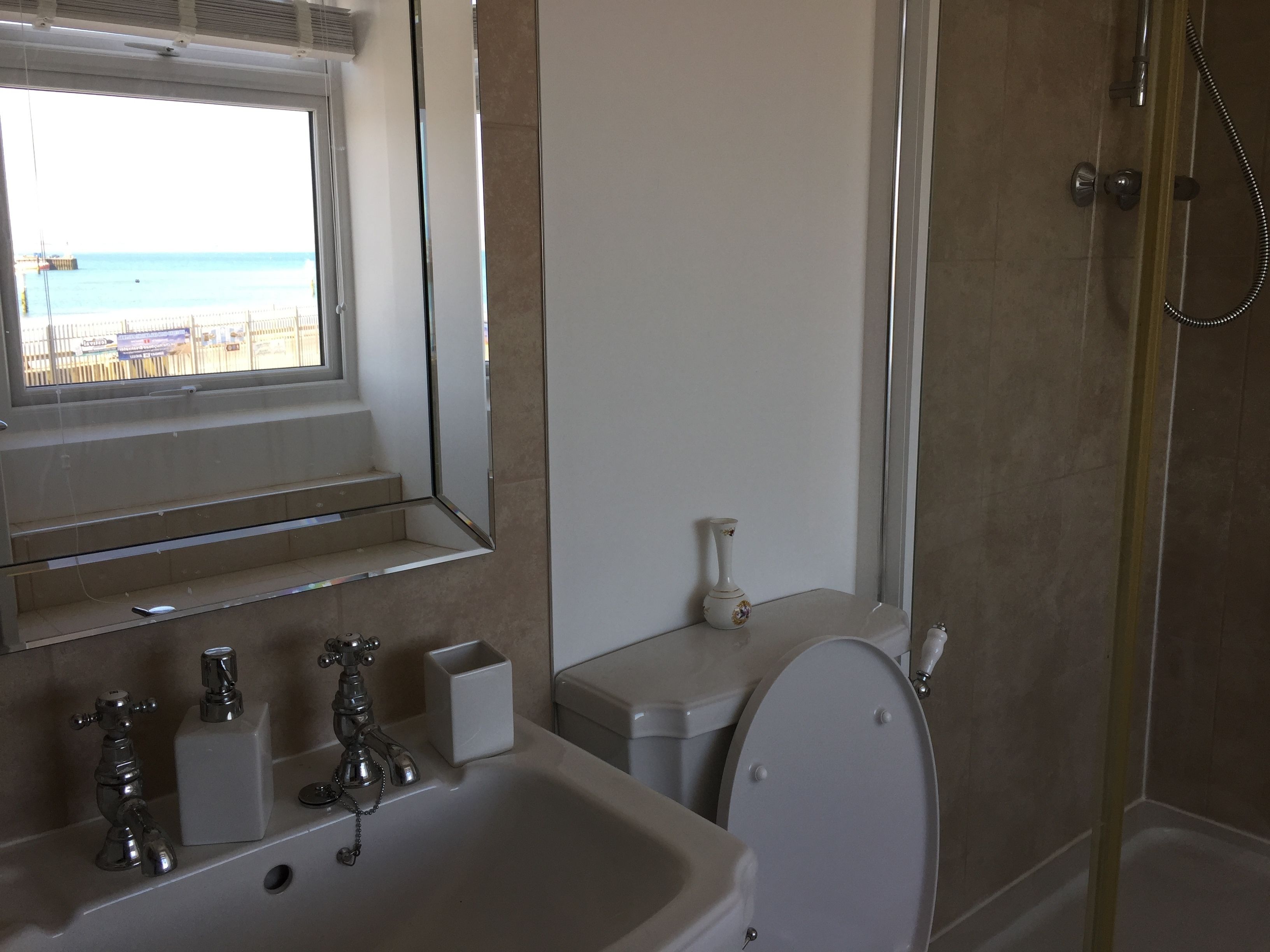 Une salle de bain avec un lavabo, des toilettes et une douche.