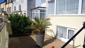 A building with a sign reading "The Beach Hut" and a large potted plant in front. - The Haven Guest House (Holyhead)