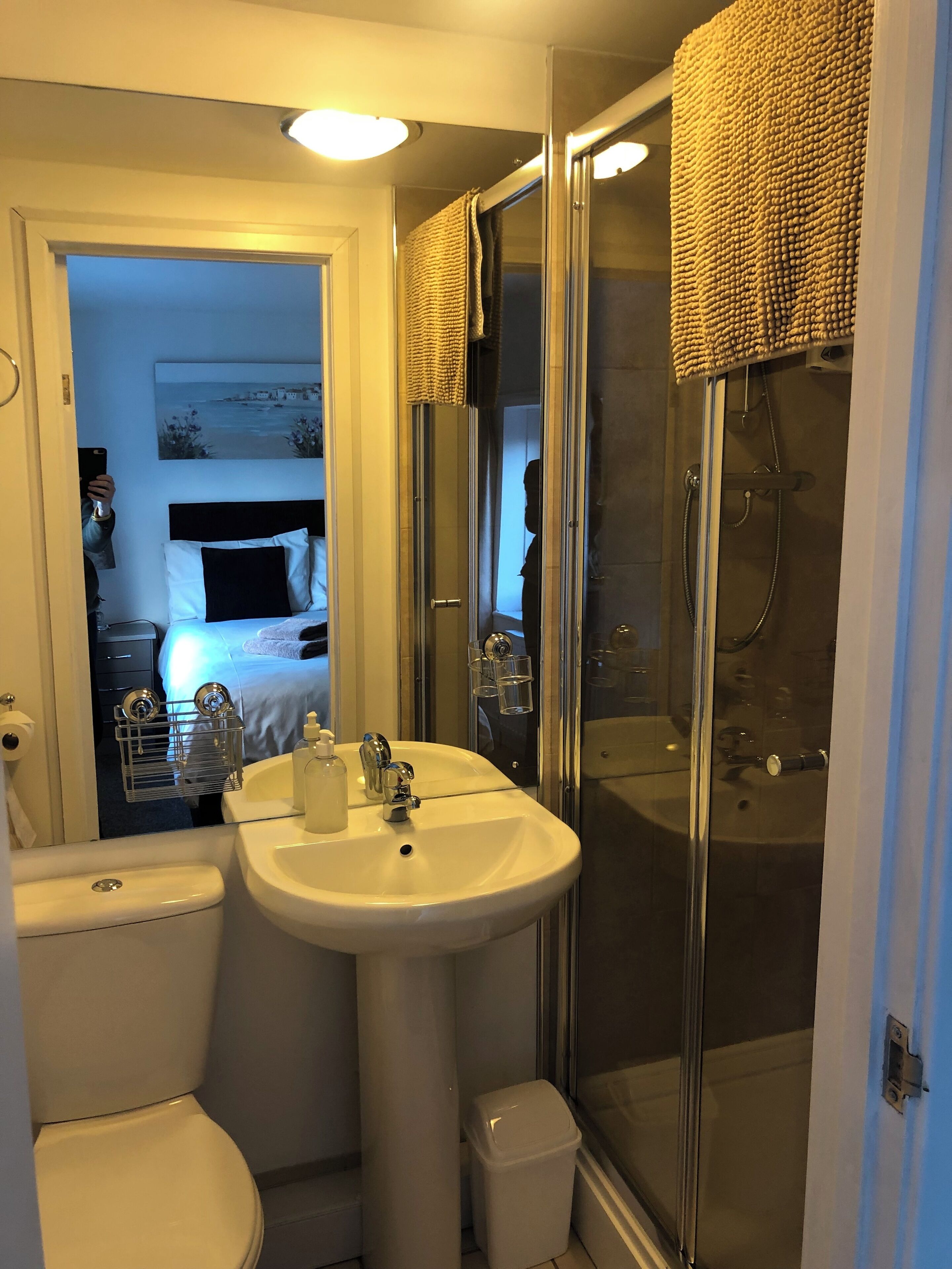 Een badkamer met een wit wastafel, toilet en douchecabine.