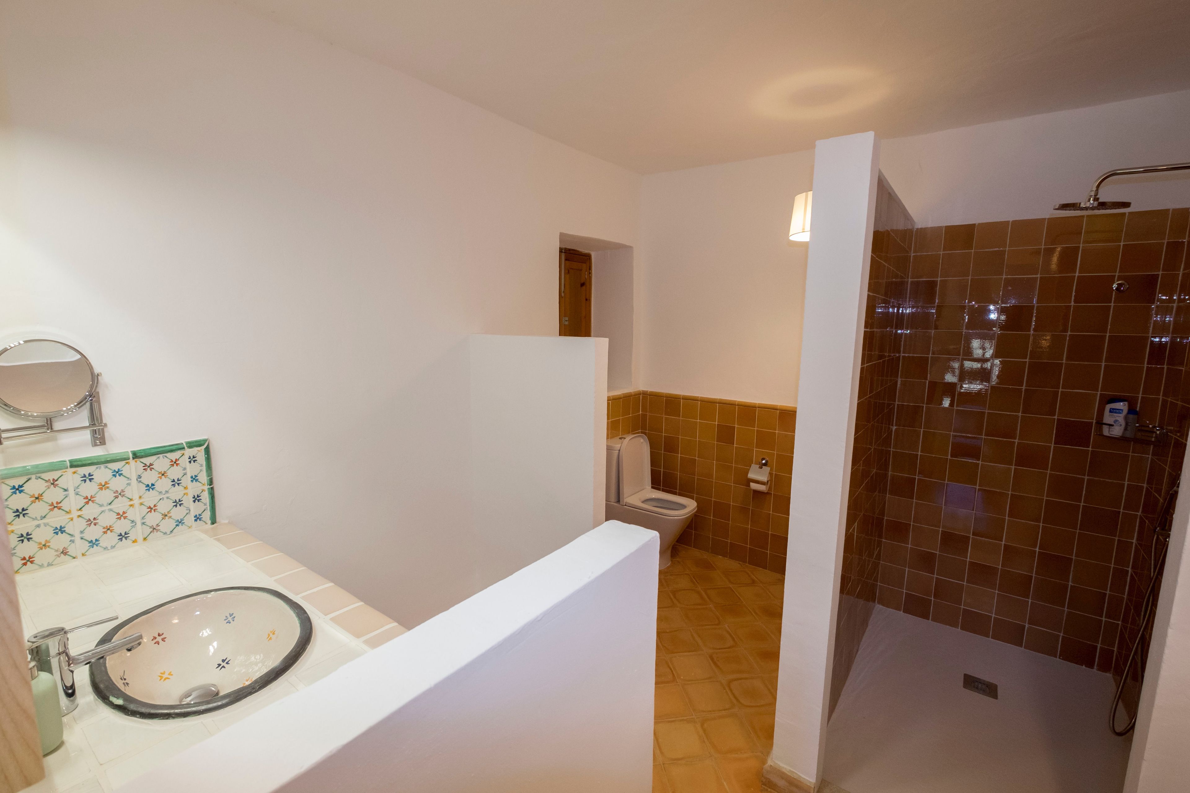 A bathroom with a sink, toilet, and shower area.