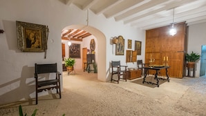 Ein Zimmer mit Holzboden, einer Bank, einem Tisch mit Kerzen und verschiedenen gerahmten Kunstwerken an den Wänden.