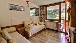Une chambre à coucher comprenant un lit, une chaise, un radiateur et une fenêtre donnant sur un paysage verdoyant.