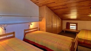 A room with two wooden beds, a wardrobe, and a small table. - Duplex for 5/6 at the slopes with balcony (La Plagne)