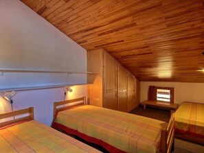 Ein Zimmer mit zwei Holzbett, einem Kleiderschrank und einem kleinen Tisch.