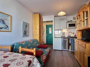 Ein gemütlicher Raum mit Bett, Küchenzeile und Essbereich.