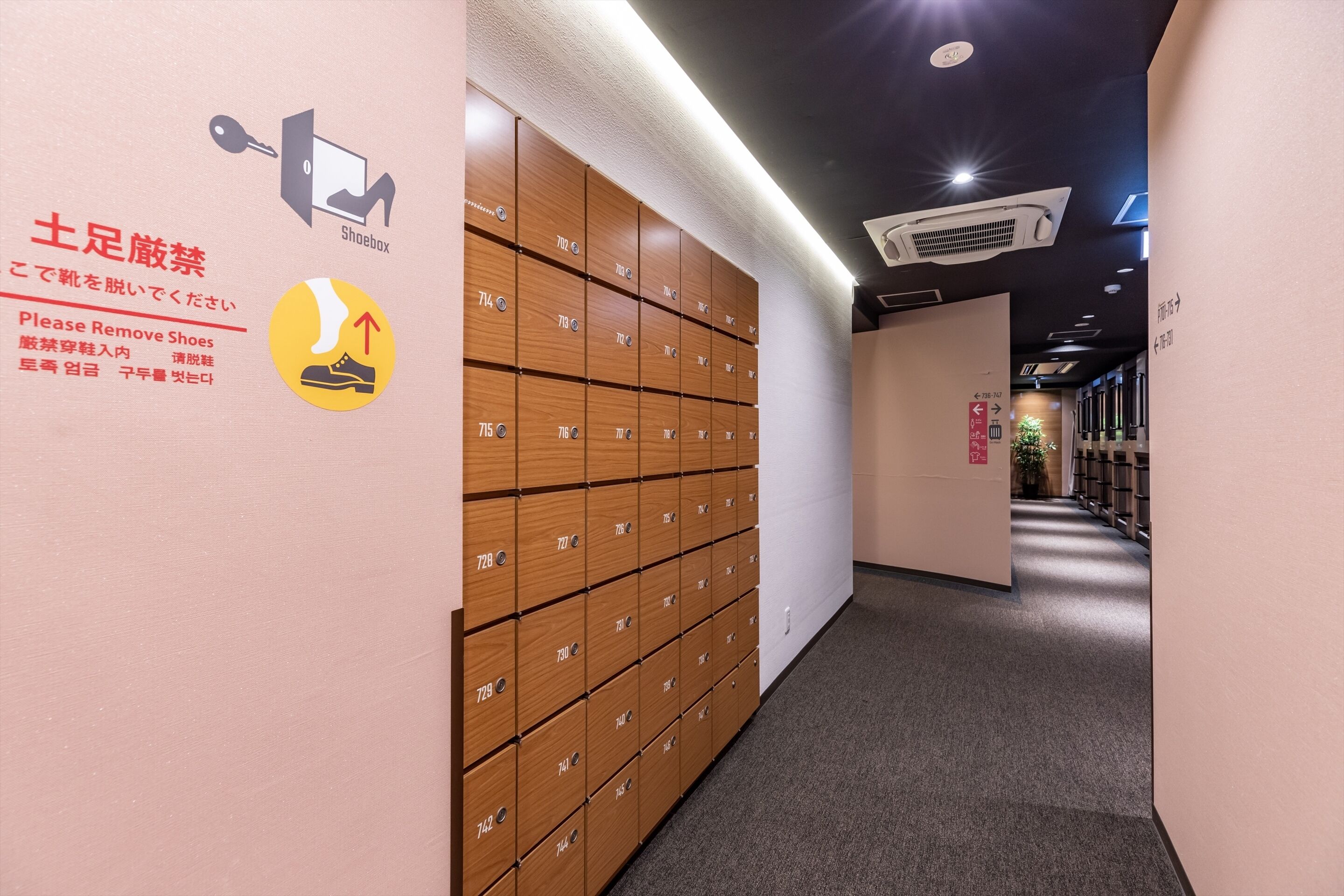 A hallway with shoe storage lockers and a shoe box sign.