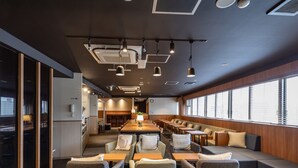 A modern conference room with a long table, multiple chairs, and a seating area with sofas. - Tabist CapsuleHotel APODS Himeji Station (Himeji)
