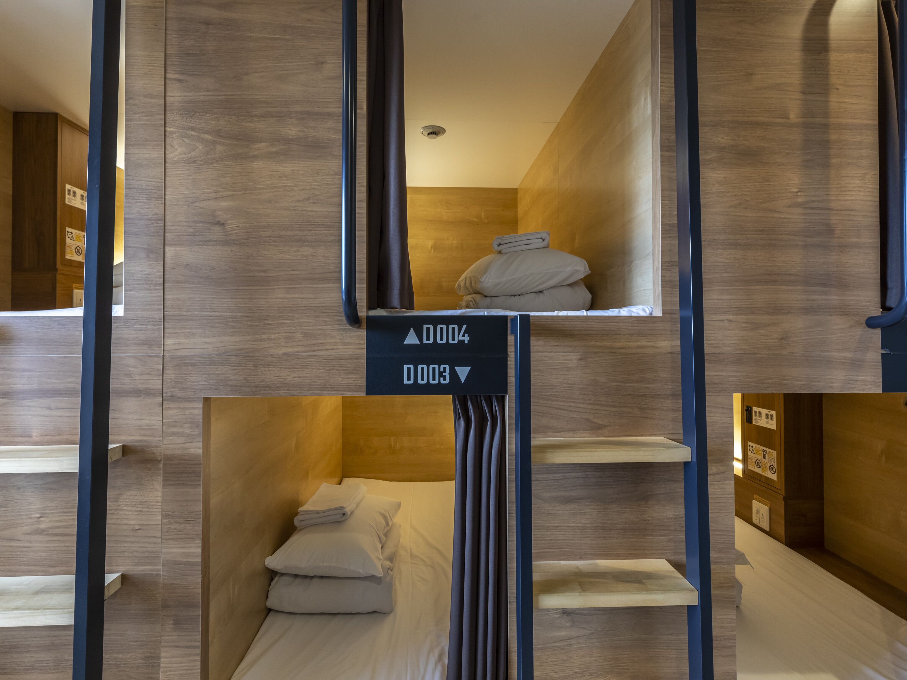 Ein Hotelzimmer mit Stockbetten, Holzwänden und einem Schild mit Zimmernummern.