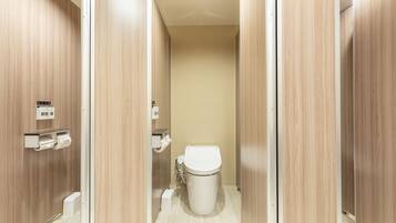 Un baño moderno con paneles de madera, un inodoro y un dispensador de toallas de papel.