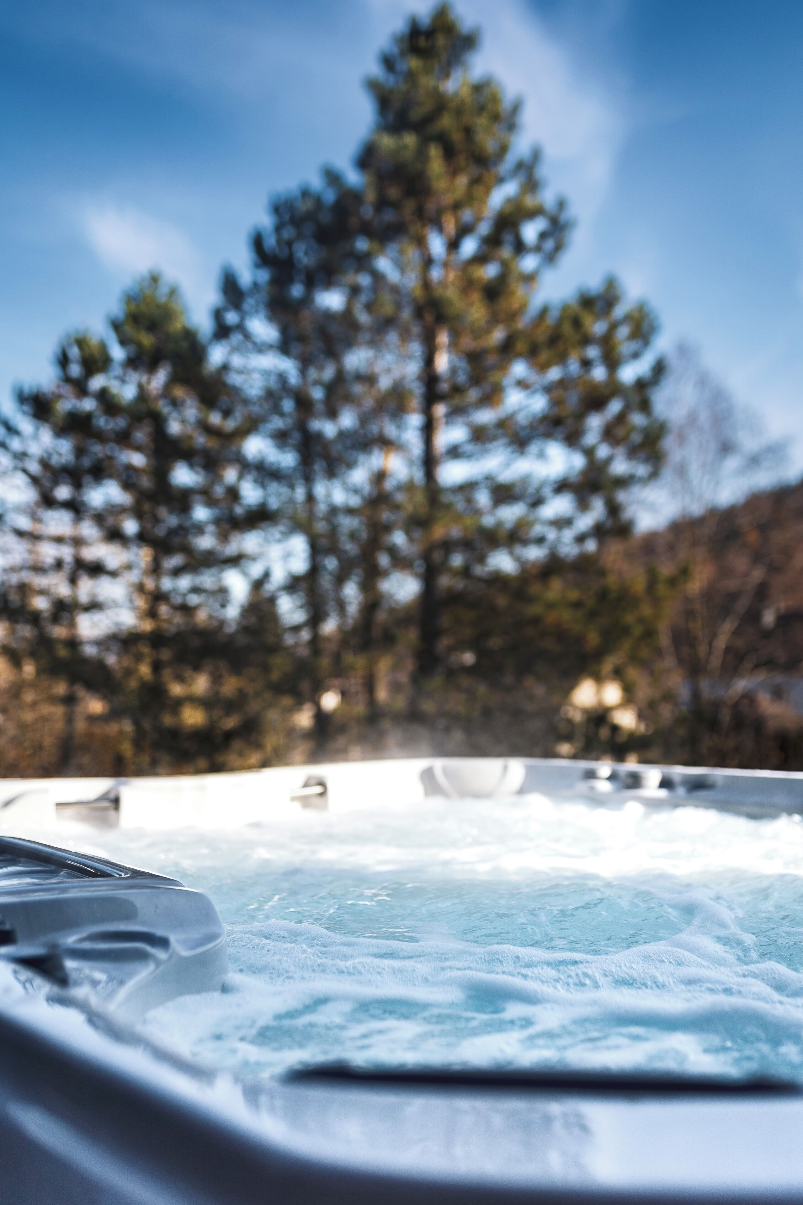 Ein Whirlpool mit Blick auf Bäume und Berge im Hintergrund.