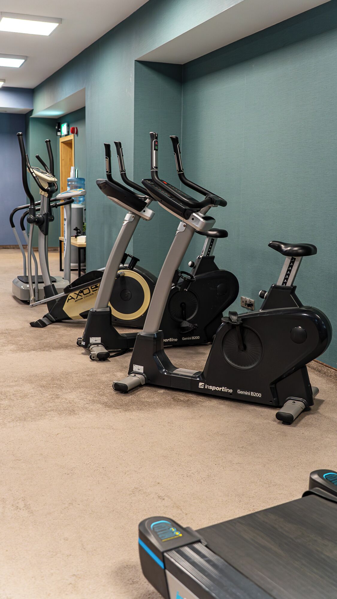 Un gimnasio con bicicletas estáticas y una cinta de correr.