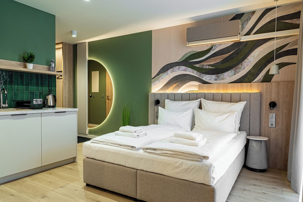 A modern hotel room with a bed, bedside table, and a view of the bathroom.