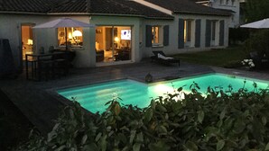 A house with a swimming pool, a patio with outdoor furniture, and a large window overlooking the pool. - La Maison des Eaux Claires (Puymoyen)