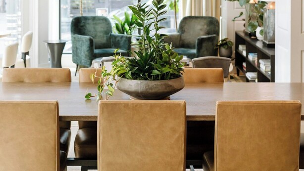 A dining area with a large table, leather chairs, hanging pendant lights, and a view of the city through large windows. - Woodlark Hotel Portland, a Tribute Portfolio Hotel (Portland)
