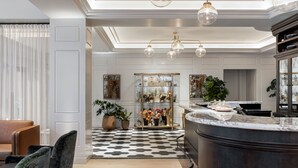 A modern kitchen with a black and white checkered floor, a marble countertop, and a glass-enclosed display cabinet with flowers. - Woodlark Hotel Portland, a Tribute Portfolio Hotel (Portland)