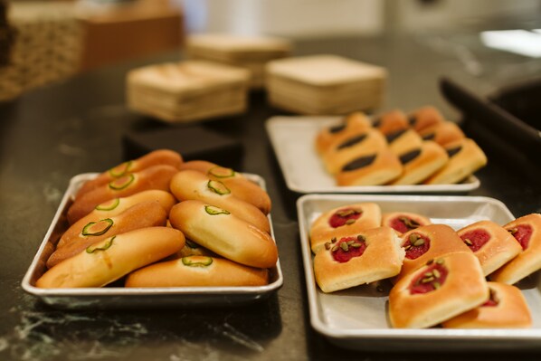 Trays of pastries with green and red toppings.