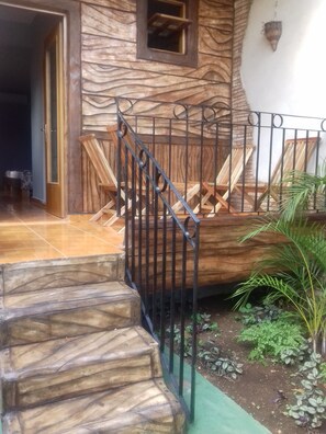 A staircase with a metal railing leading to a wooden deck with chairs. - Hostal Doña Cristina de Anita y Manel (Trinidad)