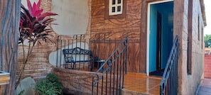 Staircase leads to an upper level with a bench and a potted plant.