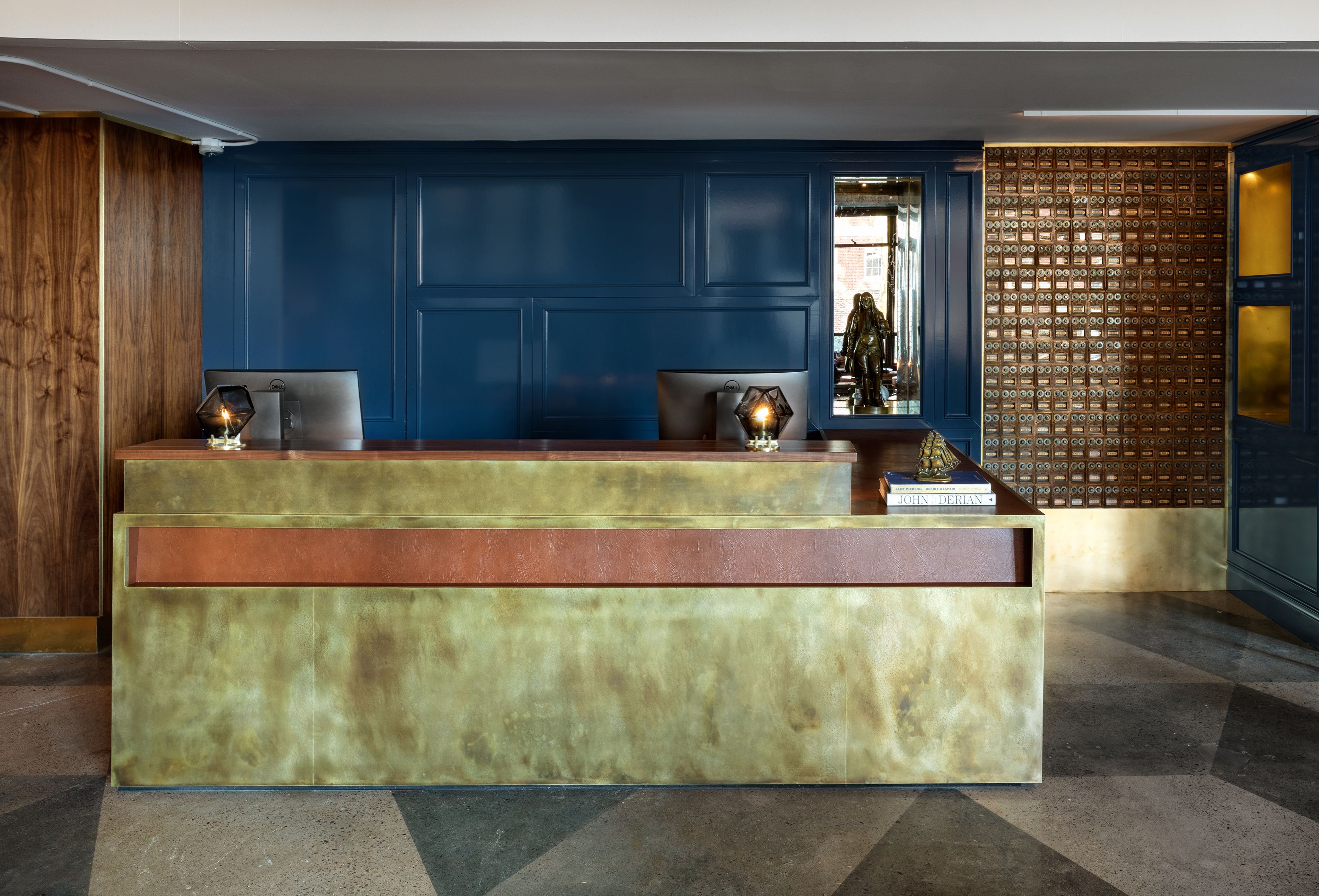 A reception desk with a blue wall and a decorative panel.