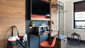 A modern room with a desk, chair, and a small table with books.