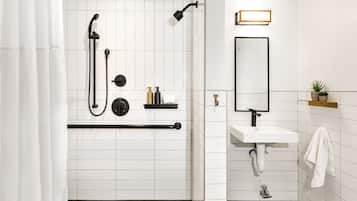 Een moderne badkamer met douche, toilet en wastafel.