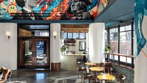 Un intérieur moderne avec un bar, des sièges et une fresque peinte au plafond.