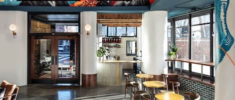A modern interior with a bar area, seating, and a mural on the ceiling.