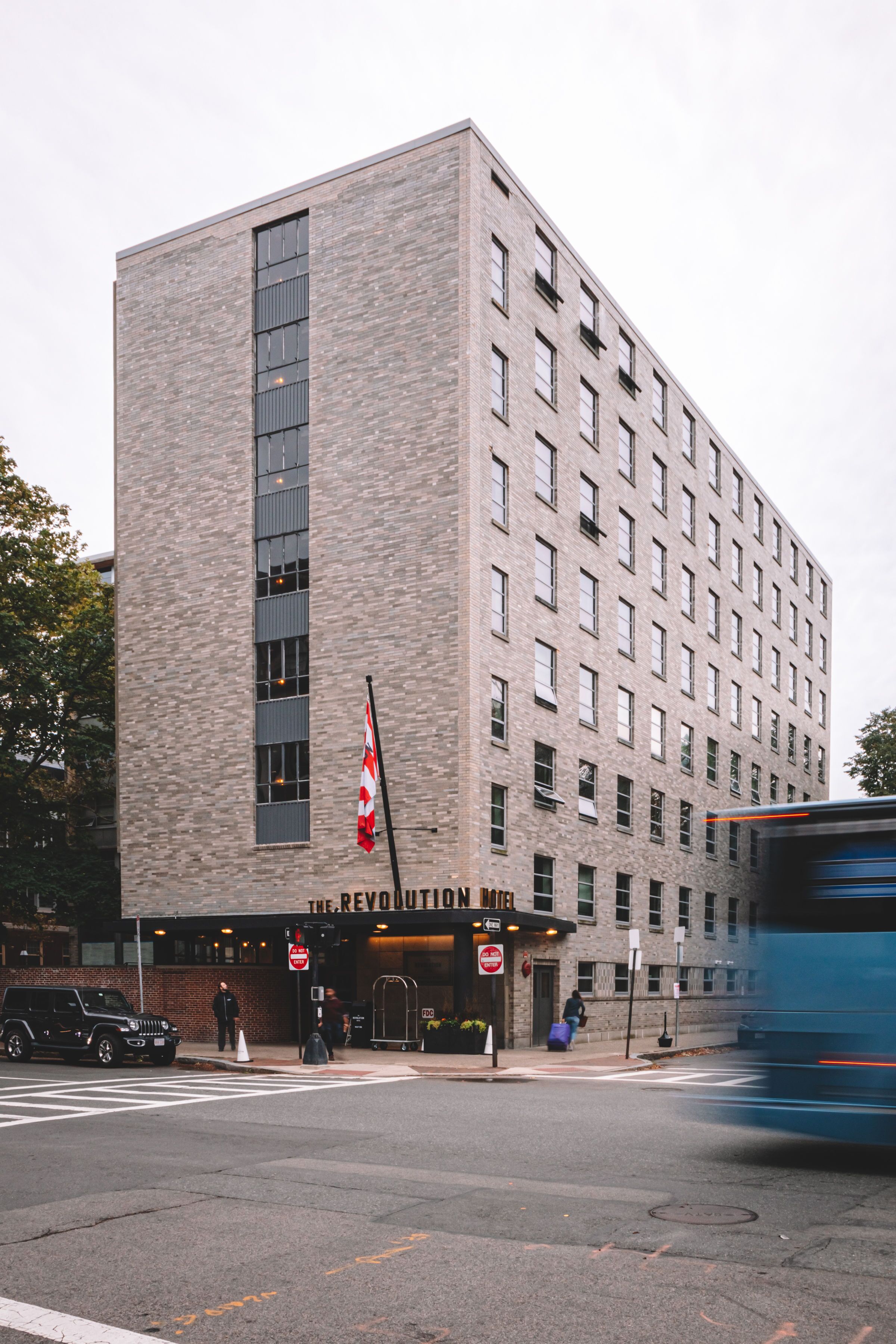 A multi-story building with a brick facade and a vertical window alignment.