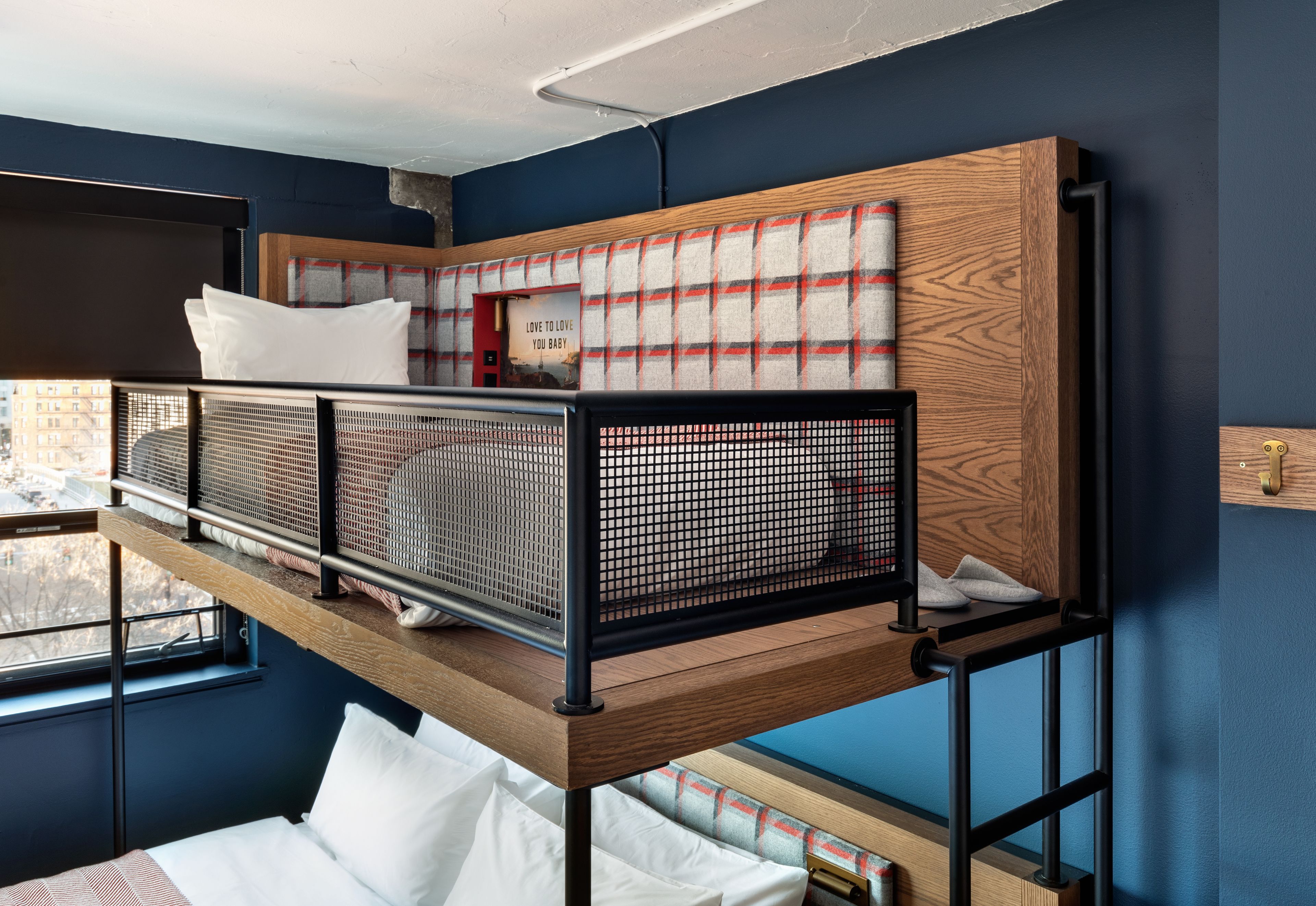 Una cama litera con cabecera estampada de cuadros y un letrero que dice "Love to love you baby".