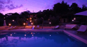 Una piscina al aire libre, sombrillas, tumbonas