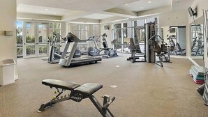 A gym with treadmills, elliptical machines, and weightlifting equipment.