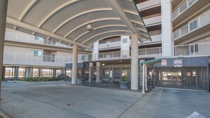 A multi-level parking garage with a covered entrance and multiple floors.