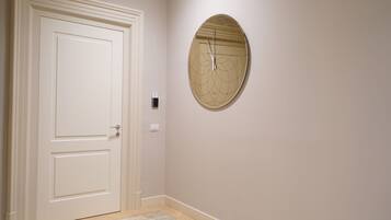 Un pasillo con una puerta blanca y un reloj de pared.